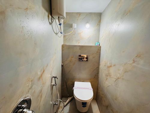 a bathroom with a white toilet in a room at Home Escape Cozy 1BHK Apartment Mahalaxmi Nagar in Indore