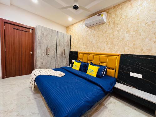 a bedroom with a blue bed with yellow pillows at Home Escape Cozy 1BHK Apartment Mahalaxmi Nagar in Indore
