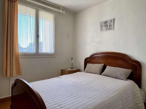 une chambre avec un lit avec des draps blancs et une fenêtre dans l'établissement Appartement 2 pièces cabine 4 couchages ARGELES SUR MER AR020-209, à Argelès-sur-Mer