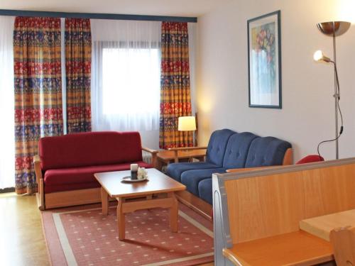 - un salon avec des chaises bleues et rouges et une table dans l'établissement Ferienhaus Nr 46, Kategorie Komfort L, Feriendorf Hochbergle, Allgäu, à Lechbruck am See