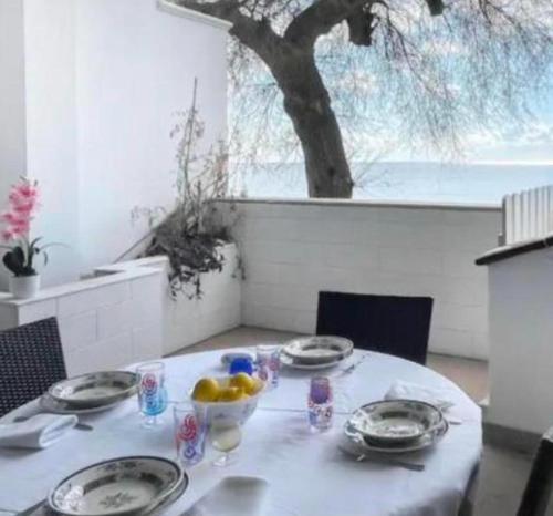 a white table with plates and bowls of fruit on it at Mediterranea in Torre Pali 