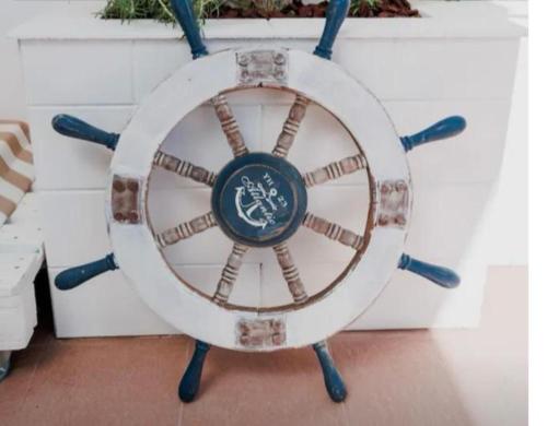 an old wooden steering wheel sitting against a wall at Mediterranea in Torre Pali 