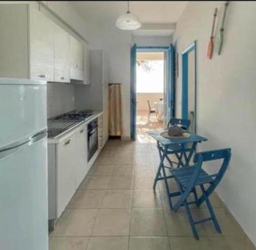 a kitchen with a small table and a refrigerator at Mediterranea in Torre Pali 