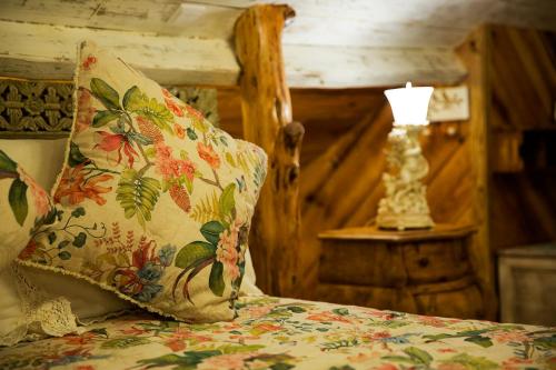 a bed with a pillow and a lamp on a table at NINHO SALOIO in Venda do Pinheiro