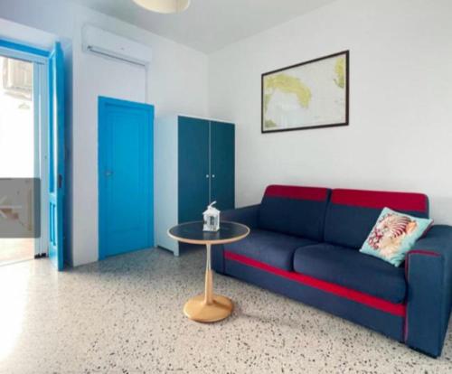 a living room with a blue couch and a table at Mediterranea in Torre Pali 