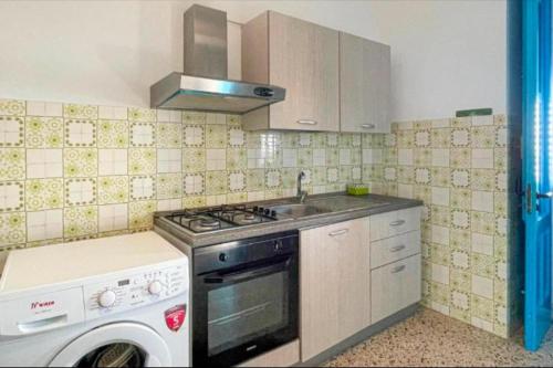 a kitchen with a stove and a sink and a dishwasher at Mediterranea in Torre Pali 