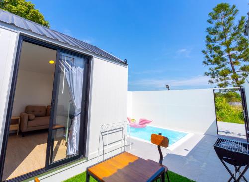a house with a balcony with a view of a pool at Chapter Pool Villa in Ban Hua Khao Sammuk