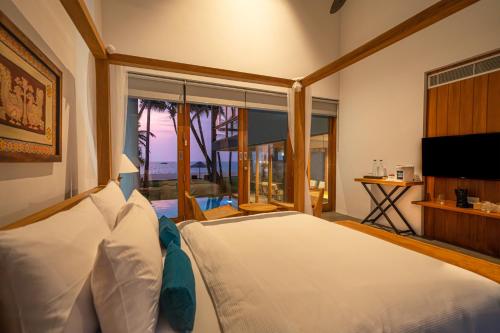 Ένα ή περισσότερα κρεβάτια σε δωμάτιο στο The Coast Sri Lanka Villa