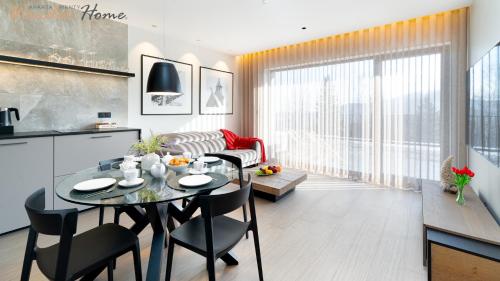 a kitchen and dining room with a table and chairs at Wonder Home - Orlik Residence - Apartamenty z widokiem na Śnieżkę, blisko wyciągów, Ski Arena i Kościółka Wang in Karpacz