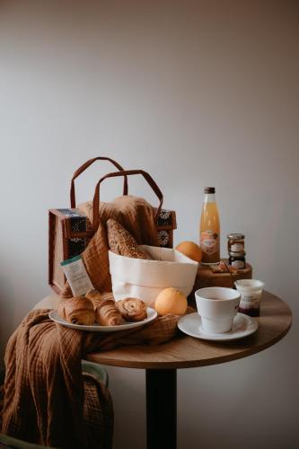 a table topped with bread and a plate of food at Appart'hôtel Le Corot - Accès Autonome - Saint-Junien Centre in Saint-Junien