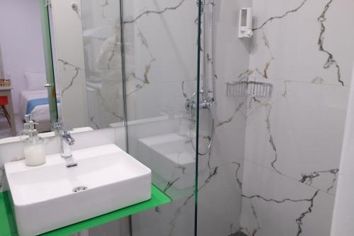 a bathroom with a sink and a glass shower at City Center Studios by Cretan Houses in Heraklio