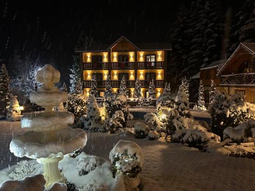 a large building with lights in the snow at Idylia Grand Villas in Migovo