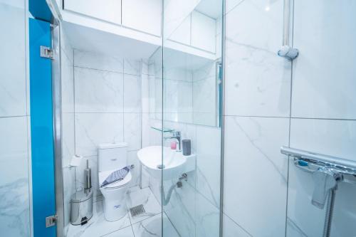 a white bathroom with a toilet and a sink at City Center Studios by Cretan Houses in Heraklio