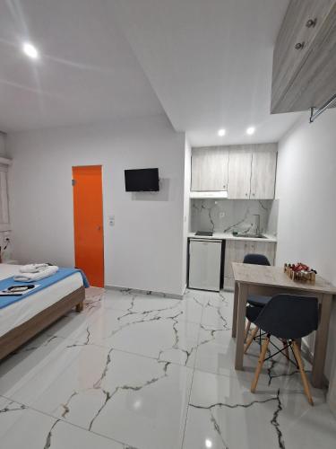 a room with a bed and a table and a kitchen at City Center Studios by Cretan Houses in Heraklio
