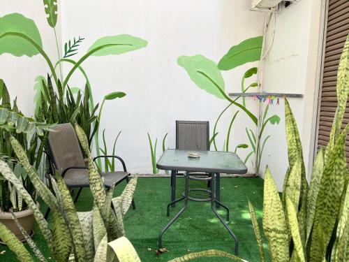 a table and chairs in a room with plants at City Center Studios by Cretan Houses in Heraklio