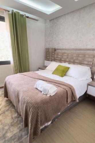 ルサカにあるCactus Apartmentsのベッドルーム1室(緑のカーテン付きの大型ベッド1台付)