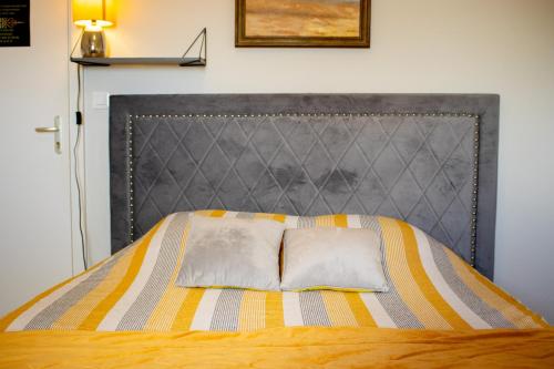 a bed with two pillows on top of it at La Villa Port Winston - Face Mer B&B in Saint-Côme-de-Fresné