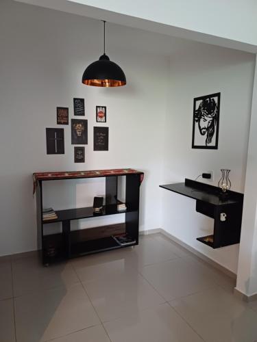 a room with a desk and a wall with pictures at Pousada Tia Rosi com suites independente 100 mts da praia c ar, energia solar e atendimento vip in Rio das Ostras