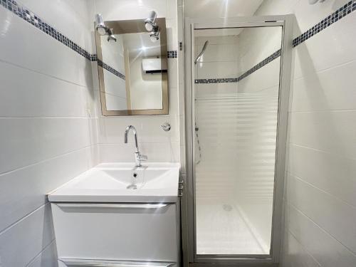 une salle de bain blanche avec un lavabo et une douche dans l'établissement Sol-y-Days jardins du couchant, à La Grande Motte