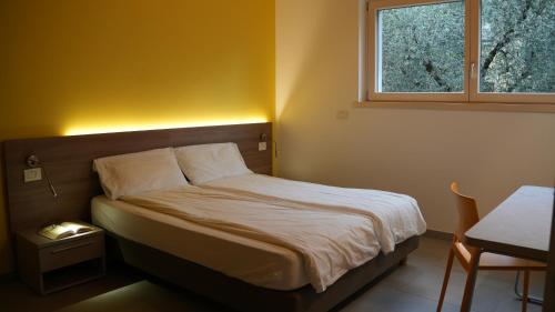 a small bed in a room with a window at Casa Maria Apartments in Riva del Garda