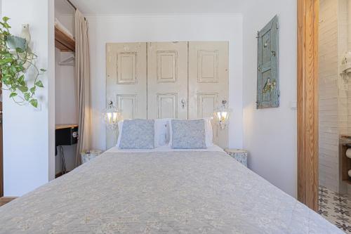 a bedroom with a large bed with blue pillows at NINHO SALOIO in Venda do Pinheiro