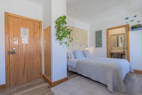 a bedroom with a bed and a potted plant at NINHO SALOIO in Venda do Pinheiro