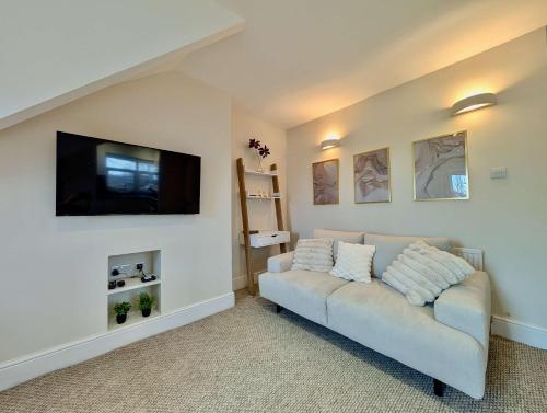 a living room with a couch and a flat screen tv at Stunning Property with Garden and Parking in Finchley