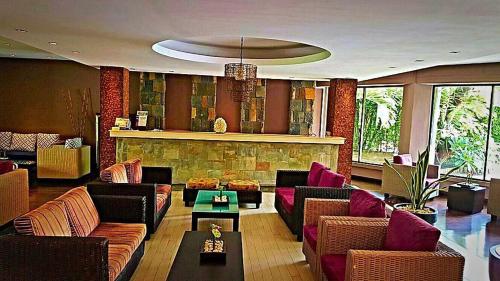 a lobby with couches and chairs and a bar at Ocean Villas Apart Hotel in Grand Baie