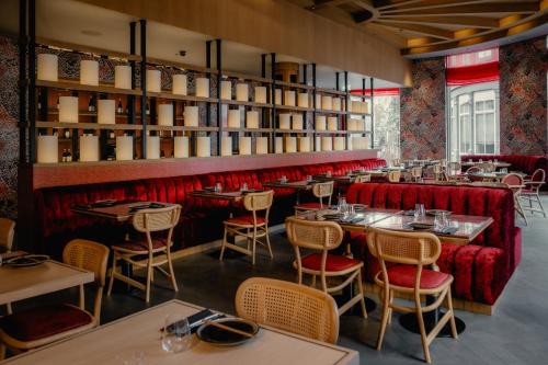 a restaurant with red booths and tables and chairs at Hart Shoreditch Hotel London, Curio Collection by Hilton in London