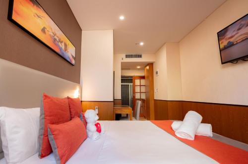 a teddy bear sitting on a bed in a room at YEHS Hotel Sydney QVB in Sydney