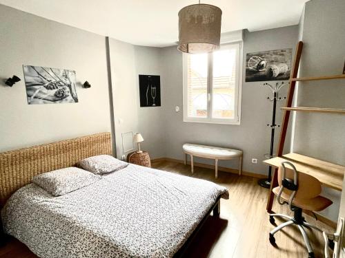 a bedroom with a bed and a desk and a window at Le Lodge Champenois in Épernay