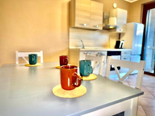 three cups sitting on a table in a kitchen at Airport House 2' from MXP, 15' public shuttle free in Case Nuove