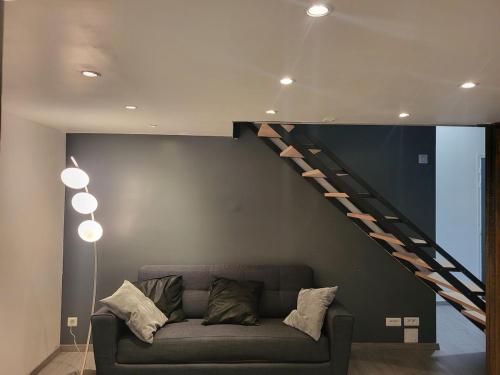 un salon avec un canapé et un escalier dans l'établissement Le Loft, à Épinal