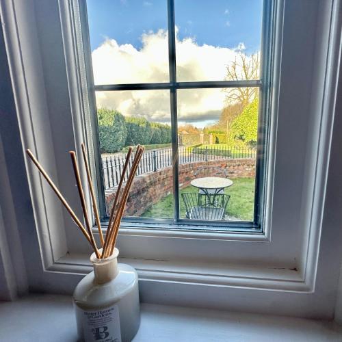 a window with sticks in a vase on a window sill at Briarwood nr Manchester Airport/Wilmslow in Wilmslow