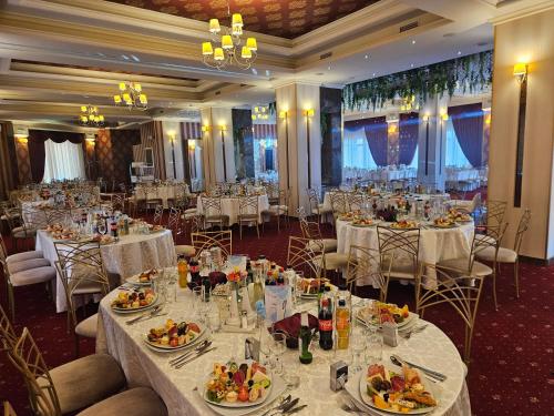 a banquet hall with tables and chairs with food on them at Hotel Bulevard in Făgăraş