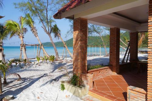 a brick house on the beach with palm trees at SoonNoeng Resort in Koh Rong Sanloem