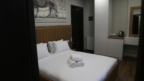 a bedroom with a bed with two towels on it at Golden Sun Kobuleti in K'obulet'i