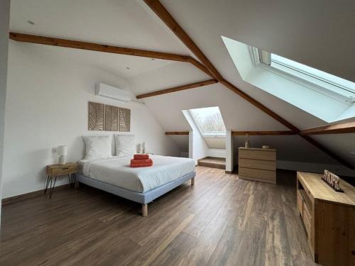 - une chambre mansardée avec un lit et une lucarne dans l'établissement House Disney BBQ Jacuzzi 6P, à Montévrain