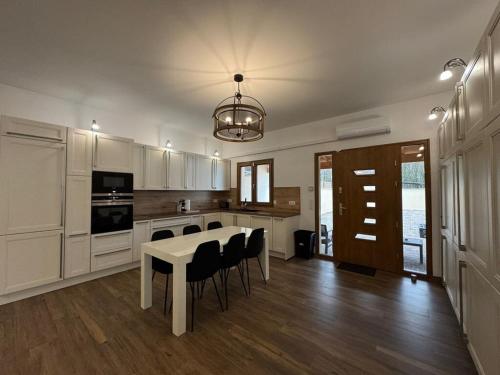 une cuisine avec une table blanche et des chaises dans l'établissement House Disney BBQ Jacuzzi 6P, à Montévrain