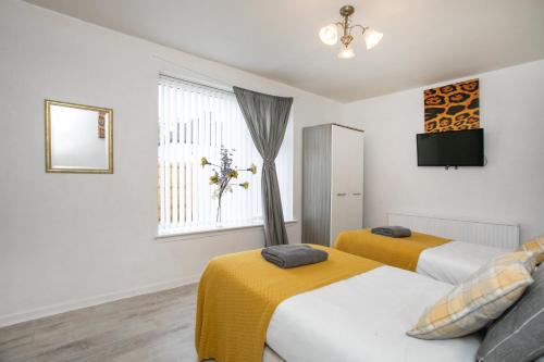 ein Schlafzimmer mit zwei Betten und einem Fenster in der Unterkunft Tsalach Short Lets in Nottingham