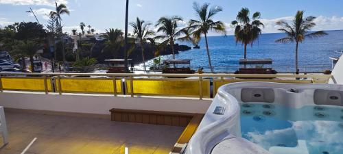 a hot tub on a balcony overlooking the ocean at Seafront Playa La Arena in Puerto de Santiago