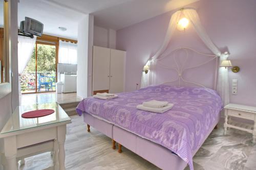 a purple bedroom with a purple bed and a table at Sunset Hotel in Petra