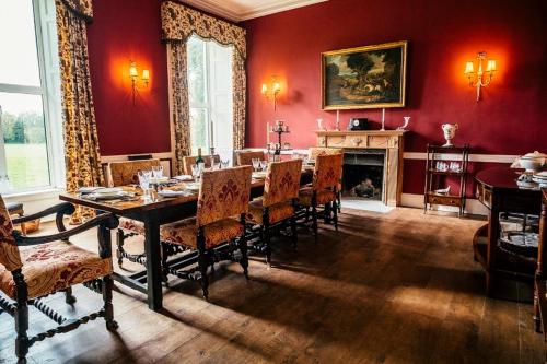 a dining room with a table and chairs and a fireplace at Ash Hill B & B in Kilmallock