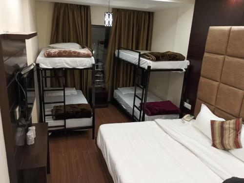 a room with three bunk beds in a room at The Bunkk Inn Hotel & Restaurant in Mussoorie
