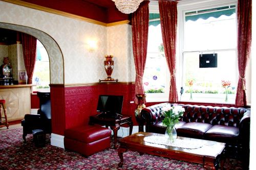 a living room with a couch and a table at Ilfracombe House Hotel - near Cliffs Pavilion in Southend-on-Sea