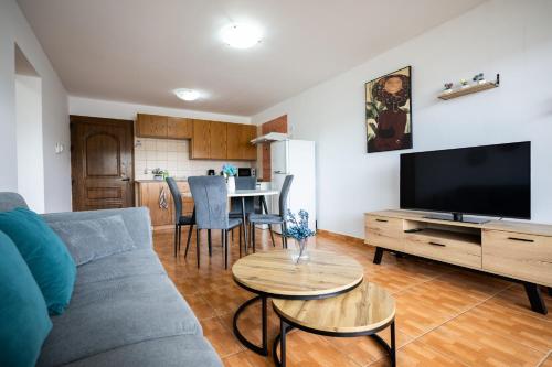 a living room with a couch and a tv and a table at Napa Centrale Suites in Ayia Napa