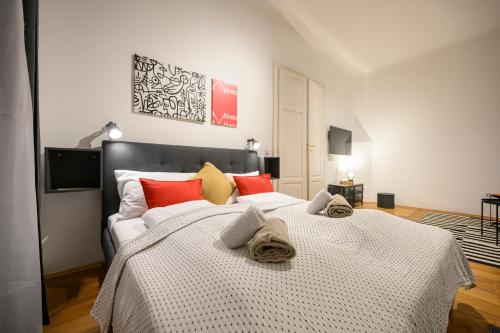 a bedroom with a large bed with red and yellow pillows at Spacious apartment in Graz for 6 people in Graz
