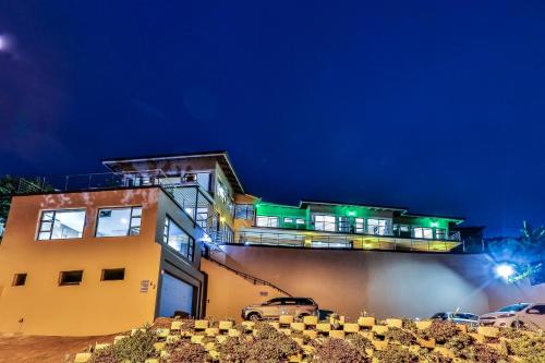 a building with cars parked in front of it at night at Zimbali View Eco Guesthouse in Ballito