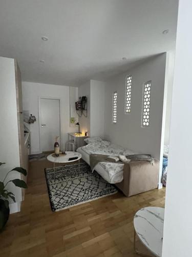 une chambre blanche avec un lit et une table dans l'établissement Studio Cocon, à Lingolsheim