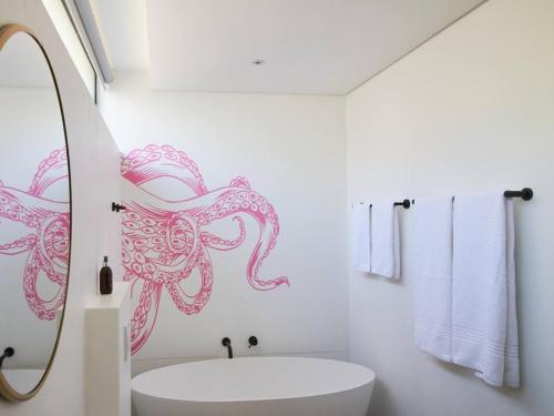a bathroom with a sink and an octopus sticker on the wall at Central Beach Villas in Cape Town